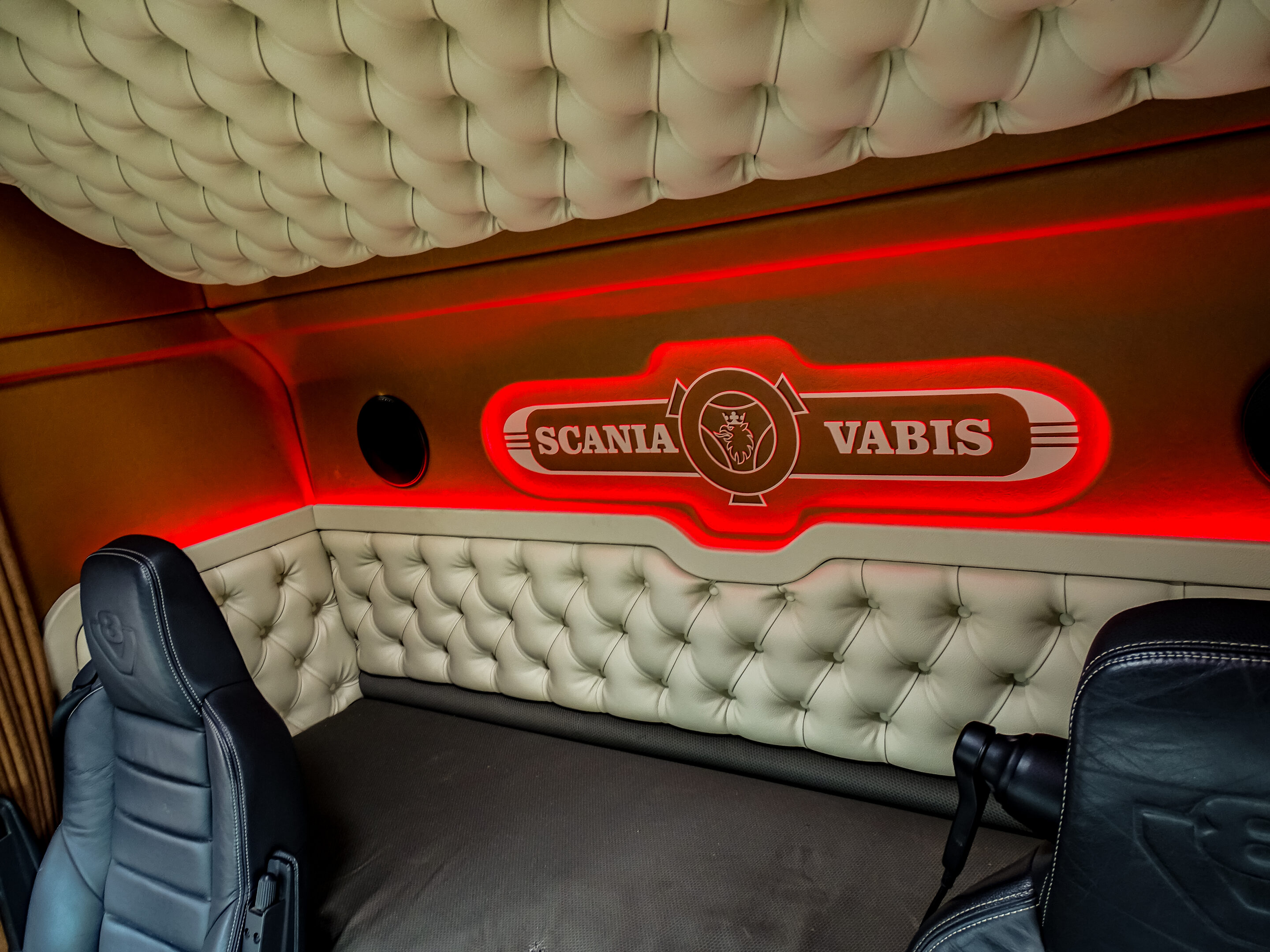 Half geknoopt half vlak met scania vabis logo achterwand